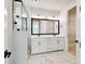 A well-lit bathroom with double vanity, framed mirrors, marbled floors and a glass walk-in shower at 4717 W Mccoy St # 9, Tampa, FL 33616