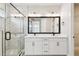 Well-lit bathroom features a double vanity, framed mirrors, marbled floors, and a glass walk-in shower at 4717 W Mccoy St # 9, Tampa, FL 33616