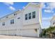 Modern white townhome with a two-car garage and ample natural light against a blue sky at 4717 W Mccoy St # 9, Tampa, FL 33616