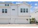 Exterior view of the townhome featuring a white facade, multiple windows, and an attached garage at 4717 W Mccoy St # 9, Tampa, FL 33616