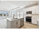 Modern kitchen featuring an island with sink, stainless steel appliances, and view into a spacious living area at 4717 W Mccoy St # 9, Tampa, FL 33616