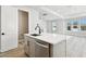 Bright, modern kitchen island with sink, stainless steel appliances, gray cabinets, and access to living area at 4717 W Mccoy St # 9, Tampa, FL 33616