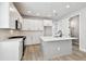 Bright, modern kitchen features white cabinets, stainless steel appliances, and a central island with a sink at 4717 W Mccoy St # 9, Tampa, FL 33616