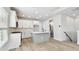 Modern kitchen with white cabinets, stainless appliances, island with sink, and view of a powder room at 4717 W Mccoy St # 9, Tampa, FL 33616