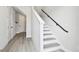 Staircase with white risers and gray treads with a black handrail and light colored laminate flooring at 4717 W Mccoy St # 9, Tampa, FL 33616