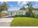 Charming single-story home featuring a well-manicured lawn, lush shrubbery, and a welcoming front porch at 4834 W Flamingo Rd, Tampa, FL 33611