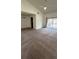 Open living room featuring neutral carpet, vaulted ceilings, fan and sliding doors to balcony at 4983 Puritan Cir # 524, Tampa, FL 33617