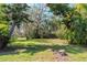 Expansive backyard featuring lush greenery, mature trees, and a rustic wooden fence at 5101 Estates Cir, Sarasota, FL 34243