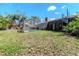 Backyard with a screened pool enclosure, metal spiral staircase, and red brick chimney at 5101 Estates Cir, Sarasota, FL 34243