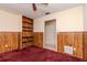 Bedroom featuring wood paneling, a built-in bookshelf, and neutral colored walls at 5101 Estates Cir, Sarasota, FL 34243