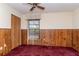 A bedroom with a ceiling fan, closet, window and wood paneling at 5101 Estates Cir, Sarasota, FL 34243
