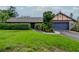 Charming single-story home featuring a lush front lawn, a blue two-car garage and an inviting entryway at 5101 Estates Cir, Sarasota, FL 34243