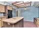 Classic kitchen featuring light wood cabinets, an island, and unique overhead lighting at 5101 Estates Cir, Sarasota, FL 34243