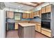 Kitchen features classic oak cabinets, an island, and double oven perfect for cooking at 5101 Estates Cir, Sarasota, FL 34243