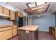 The kitchen features wood cabinets, a center island, brick floor and blue plaid wallpaper at 5101 Estates Cir, Sarasota, FL 34243