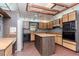 Kitchen with wood cabinets, brick floor and a center island at 5101 Estates Cir, Sarasota, FL 34243