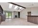 Living room with a stone fireplace, beamed ceiling, and sliding glass doors to the outside at 5101 Estates Cir, Sarasota, FL 34243