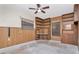Living room featuring wood paneled walls, built in shelving, and natural light from two windows at 5101 Estates Cir, Sarasota, FL 34243