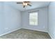 This carpeted bedroom has a ceiling fan and a window with natural light at 6262 Timberly Ln # 99, Zephyrhills, FL 33542