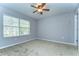 This carpeted bedroom features a ceiling fan and a window with natural light at 6262 Timberly Ln # 99, Zephyrhills, FL 33542