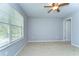 This carpeted bedroom features a ceiling fan and a large window with natural light at 6262 Timberly Ln # 99, Zephyrhills, FL 33542