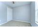This carpeted bedroom features a window with blinds and double door closet at 6262 Timberly Ln # 99, Zephyrhills, FL 33542