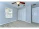 A carpeted bedroom features a ceiling fan, window with blinds, and double door closet at 6262 Timberly Ln # 99, Zephyrhills, FL 33542