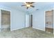 This carpeted bedroom features a ceiling fan, two doors and neutral walls at 6262 Timberly Ln # 99, Zephyrhills, FL 33542