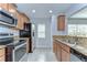 A lovely kitchen features stainless steel appliances, granite countertops, and tile flooring at 6262 Timberly Ln # 99, Zephyrhills, FL 33542