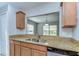 An eye-level view of a kitchen sink with granite countertops and an open window at 6262 Timberly Ln # 99, Zephyrhills, FL 33542
