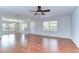 A spacious living room with wood flooring, a ceiling fan, and plenty of light at 6262 Timberly Ln # 99, Zephyrhills, FL 33542