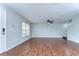 Bright and open living room with hardwood floors, a ceiling fan, and a view of the front entry at 6262 Timberly Ln # 99, Zephyrhills, FL 33542