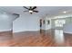 A spacious living room with wood flooring, a ceiling fan, and plenty of light at 6262 Timberly Ln # 99, Zephyrhills, FL 33542
