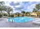 Community pool with lounge chairs and ample space for relaxation and recreation under the sunny sky at 6262 Timberly Ln # 99, Zephyrhills, FL 33542