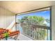 Waterfront balcony featuring a cozy orange sofa and stunning views of a canal lined with palm trees at 6317 Newtown Cir # 17B2, Tampa, FL 33615
