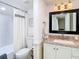 Bathroom featuring a shower with white tile, stylish curtain, granite countertop, and modern fixtures at 6317 Newtown Cir # 17B2, Tampa, FL 33615