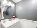 Updated half bathroom featuring a modern vanity, round mirror, and fresh gray paint at 6317 Newtown Cir # 17B2, Tampa, FL 33615