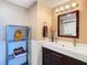 Neutral bathroom featuring a modern sink, mirror, decorative lighting, and display shelving at 6317 Newtown Cir # 17B2, Tampa, FL 33615