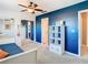 Bright bedroom with blue accent wall, ceiling fan, mirrored closet doors, and adjacent bathroom access at 6317 Newtown Cir # 17B2, Tampa, FL 33615