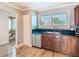 This kitchen features a stainless steel dishwasher, dark countertops and light wood floors at 6317 Newtown Cir # 17B2, Tampa, FL 33615