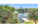 Breathtaking water view featuring lush palm trees framing a serene canal with a private dock at 6317 Newtown Cir # 17B2, Tampa, FL 33615