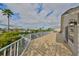 A wide-angle of a spacious, tiled balcony with white railing offering views of palm trees and waterfront homes at 6467 Rubia Cir, Apollo Beach, FL 33572