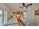 Bright bedroom features twin beds with striped bedding, a ceiling fan, and colorful wall art at 6467 Rubia Cir, Apollo Beach, FL 33572