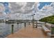 Scenic dock view showcasing a wooden walkway, boat moorings, and waterfront access amid lush greenery at 6467 Rubia Cir, Apollo Beach, FL 33572