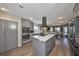 Contemporary kitchen featuring gray cabinetry, stainless steel appliances, center island, and seamless access to the dining area at 6467 Rubia Cir, Apollo Beach, FL 33572