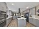 Modern kitchen featuring gray cabinets, stainless steel appliances, ample counter space, and wood-look flooring at 6467 Rubia Cir, Apollo Beach, FL 33572