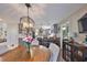 Open-concept dining area featuring a wooden table, stylish chandelier, and seamless flow into the modern kitchen at 6467 Rubia Cir, Apollo Beach, FL 33572