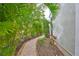 A stone-paved pathway lined with palm trees and manicured bushes runs alongside the home at 6467 Rubia Cir, Apollo Beach, FL 33572