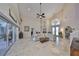 Open-concept living room featuring travertine floors, abundant natural light, and easy access to the outdoor patio and garden at 6467 Rubia Cir, Apollo Beach, FL 33572