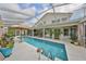 Relax by the covered lanai featuring a large pool, comfortable seating, and a serene backyard view at 6467 Rubia Cir, Apollo Beach, FL 33572